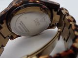 a close up of a watch on a white surface