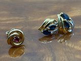 two pairs of earrings on a wooden table with water droplets