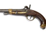 un vieux fusil exposé sur une surface blanche