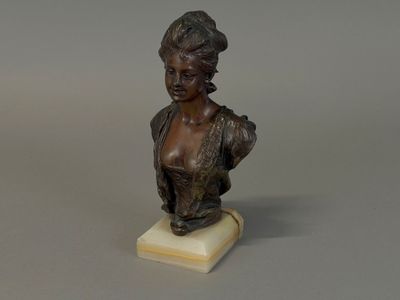bronze bust of a woman with a hat on a marble base