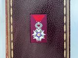 un vieux livre orné d'un ruban rouge et d'un insigne