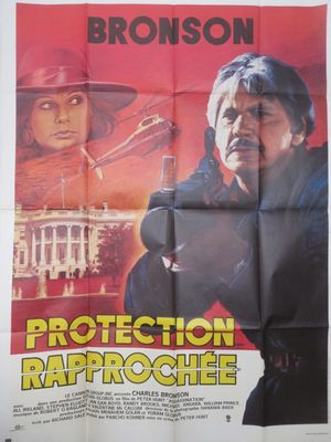 une affiche du film « Protection », sur laquelle figure un homme tenant une arme à feu