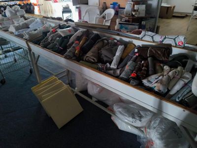 many bags of clothing on a table in a room