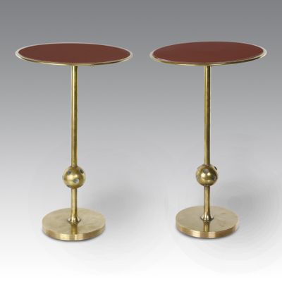 a pair of brass and red side tables