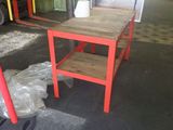 a red table and a red chair in a warehouse