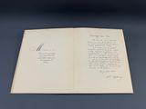 un gros plan sur un livre posé sur une table, sur lequel on peut lire une inscription manuscrite