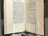 an open book sitting on a table next to a pair of candles