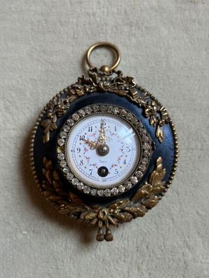 a blue and gold clock hanging on a white wall