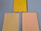 three folders of colored paper sitting on top of a blue table