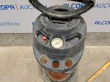 a gas can that is sitting on the ground next to a measuring tape