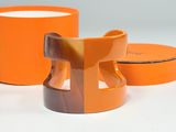 two orange containers with a brown handle and a brown lid