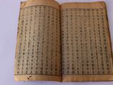 un vieux livre portant des caractères chinois, posé sur une table