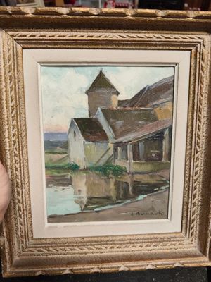 someone is holding a painting of a house by the water