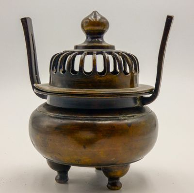 an antique bronze incense pot with a bird cage on top of it