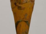 a brown vase sitting on a table with a white wall in the background