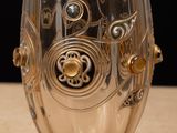 a glass cup with a design on it sitting on a table