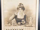 une vieille photo représentant une femme assise à une table devant une assiette de nourriture