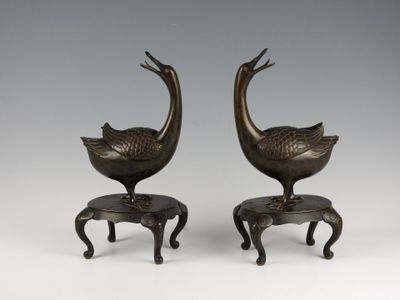pair of bronze birds on stools with legs and feet