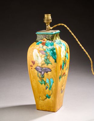 a yellow vase with a gold handle on a table