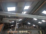 a large pipe in the middle of a building with a skylight above it