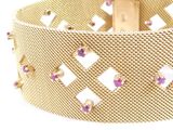 an image of a close up of a gold bracelet with pink stones