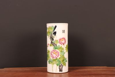 a vase with a bird on it sitting on a table