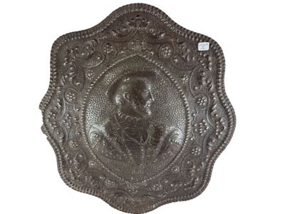 une image représentant une plaque métallique sur laquelle figure le portrait d'une femme