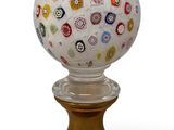 the glass ball is sitting on top of a gold stand