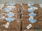 six brown shirts wrapped in plastic bags on a table