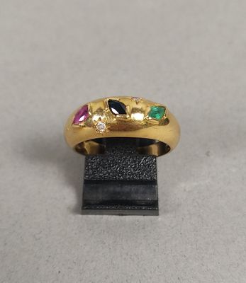 un gros plan d'une bague en or ornée de pierres multicolores