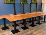 four wooden tables with black bases in a room