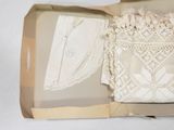 an open box with a lace doily inside of it