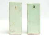 pair of green ceramic salt and pepper shakers on a white background