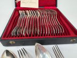 silverware in a red case with a note on top of it