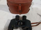 an old pair of binoculars sitting on top of a white blanket