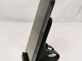 the phone is sitting on the stand on the white surface