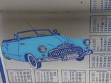 a blue and white sign with a picture of a car on it