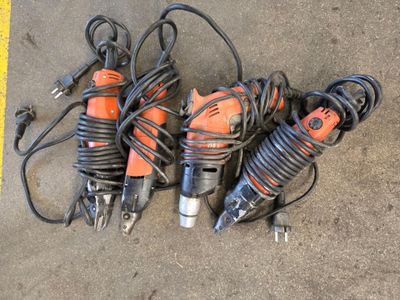 Plusieurs outils électriques sont disposés les uns à côté des autres sur le sol.