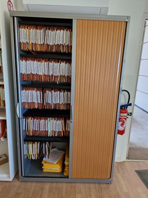 une armoire remplie de dossiers, dans un coin de la pièce
