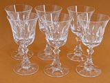 four empty wine glasses sitting on a table with a brown background