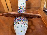 un vase surmonté d'un oiseau, posé sur une table