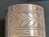 a close up of a silver cuff with a flower design