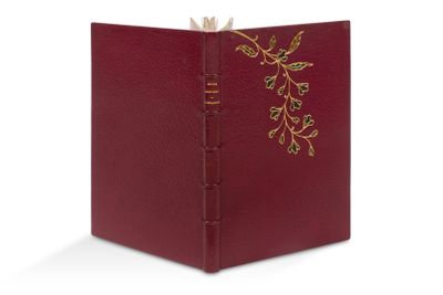 un livre rouge dont la couverture est ornée d'une décoration en feuille d'or