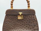 a brown ostrich ostrich leather handbag with bamboo handles