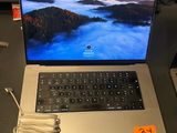 a laptop computer sitting on a desk with a charger on it