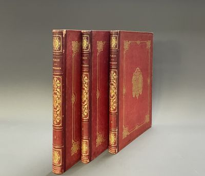 three red books with gold trims are stacked on top of each other