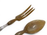 two spoons and a fork on a white surface