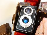 a person holding an old camera in their hand