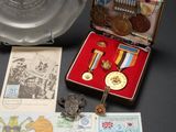 a silver plate with a medal on it next to a silver plate with a medal on it and a silver plate with a medal on it