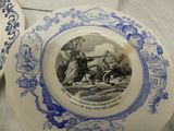two blue and white plates with a picture of a man on a horse